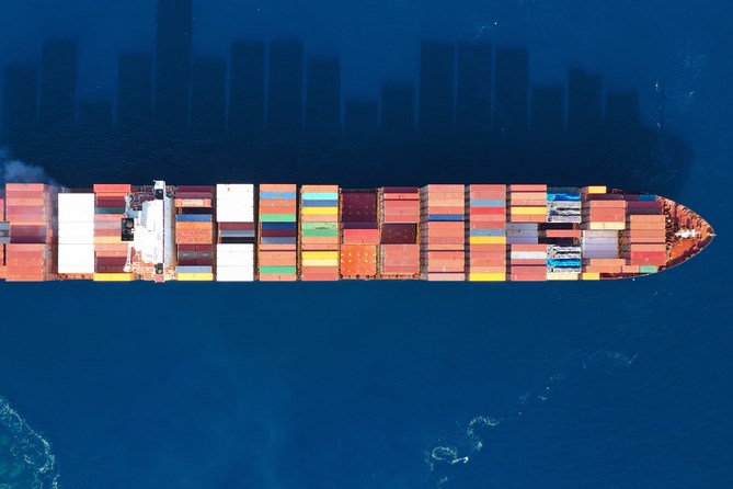 Aerial drone photo of industrial cargo container carrier cruising the open ocean deep blue sea