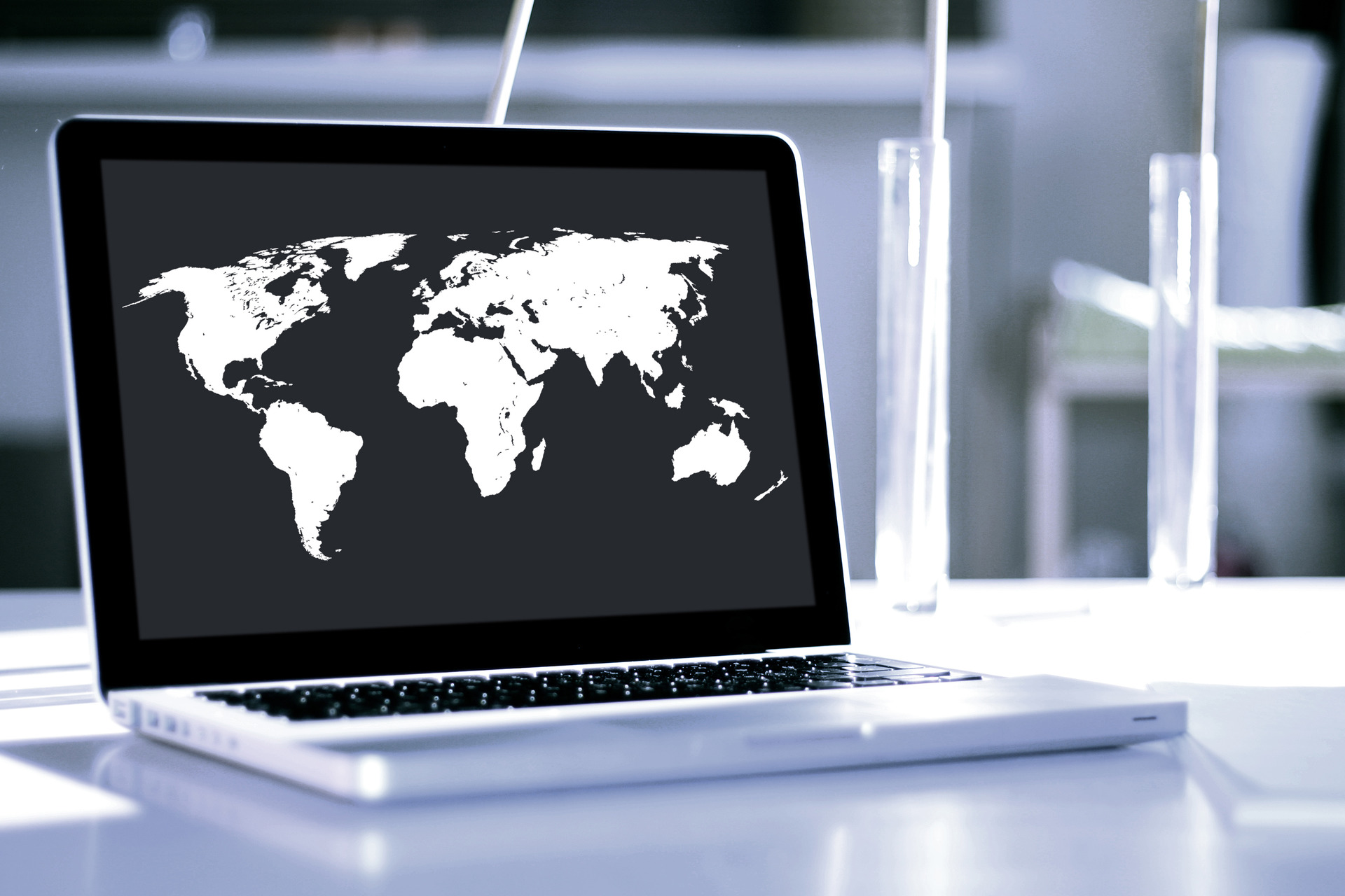 Laptop with a black and white world map as background 