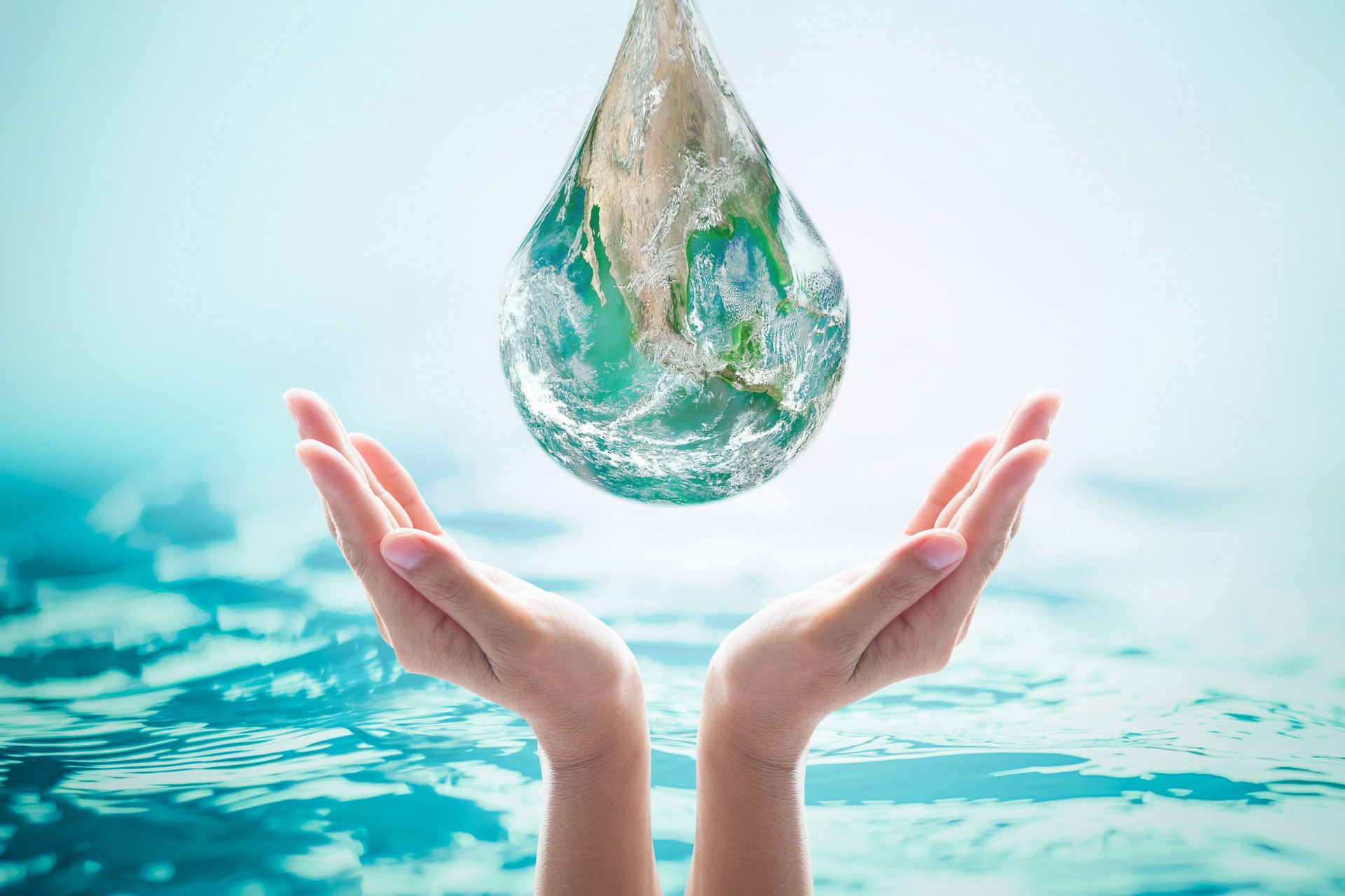 World ocean day, saving water, environmental protection, sustainable ecological ecosystems concept with green earth drop on woman's hands on sea background: Element of this image furnished by NASA