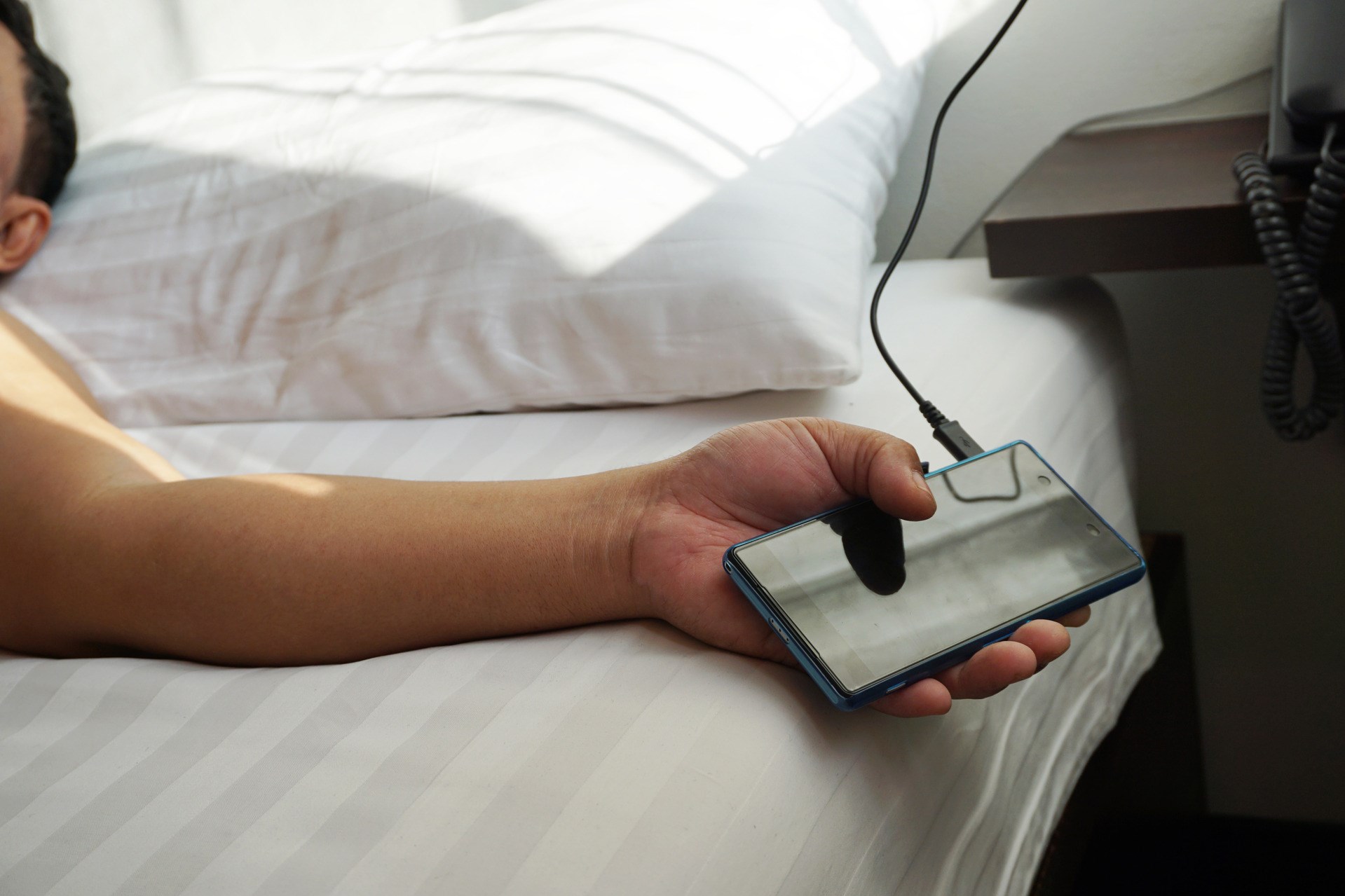 Sleeping man holding smart phone.
