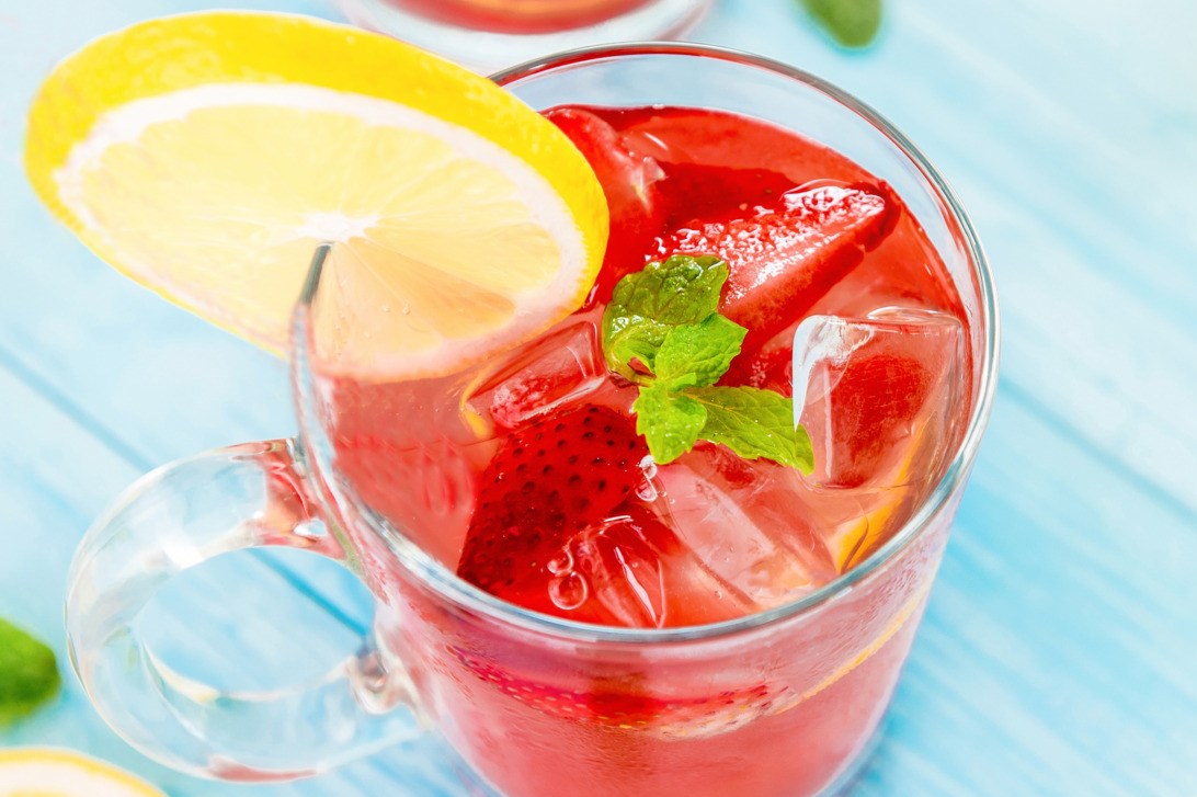 Red soft drink with strawberries & lemons