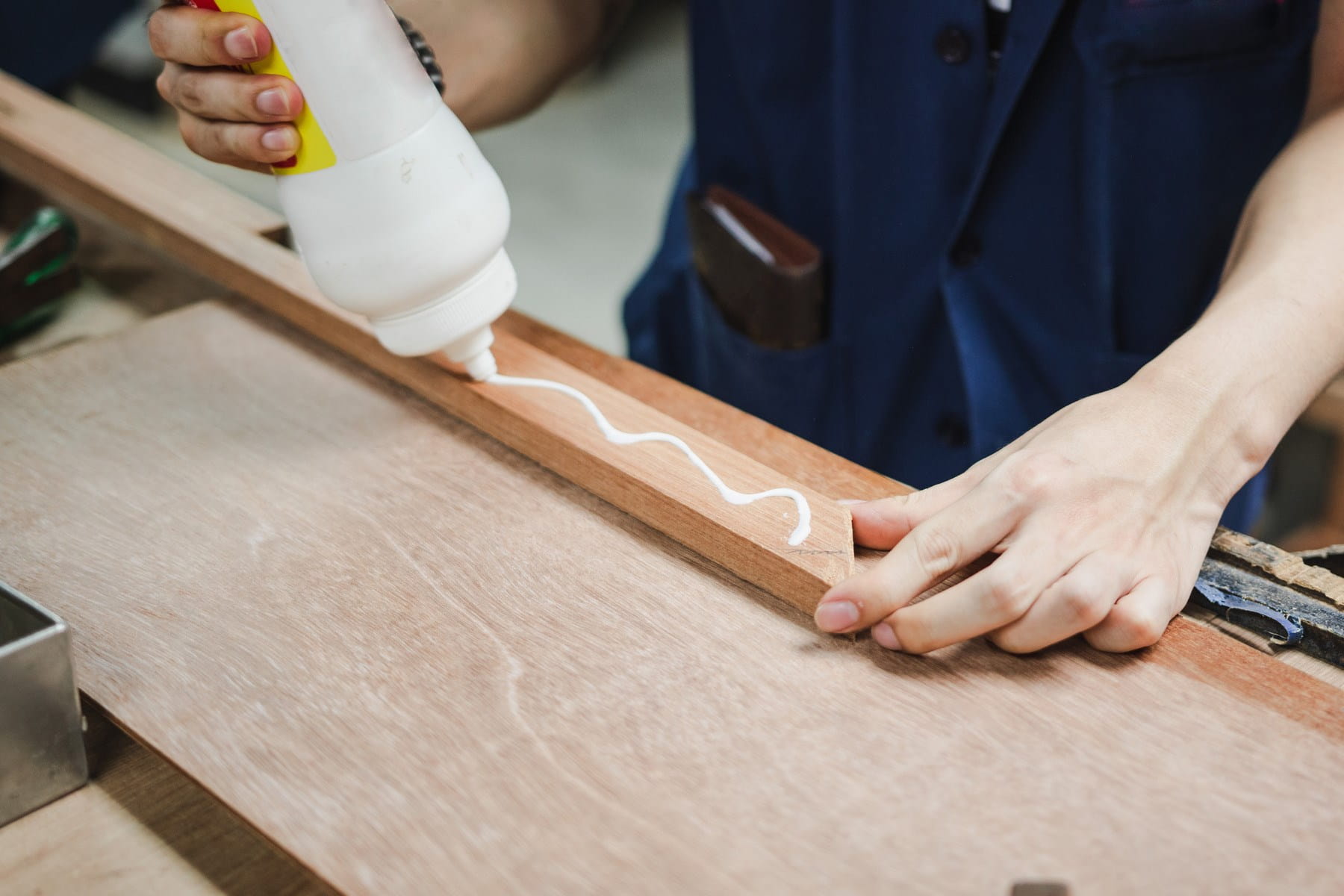 Worker use glue to stick pieces of wood together