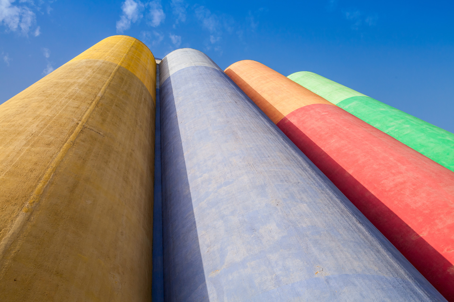 Abstract industrial architecture fragment, large colorful tanks made of concrete for storage of bulk materials