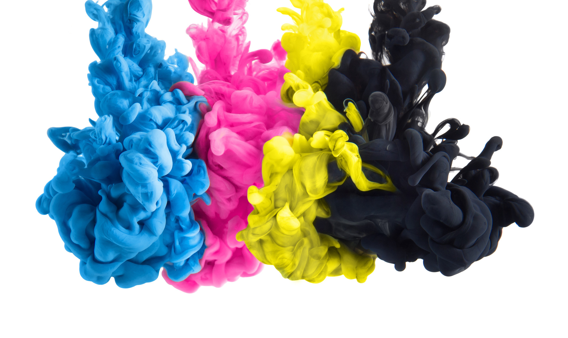 Color splashes of ink in cyan magenta yellow black as symbol for subtractive CMYK color blending