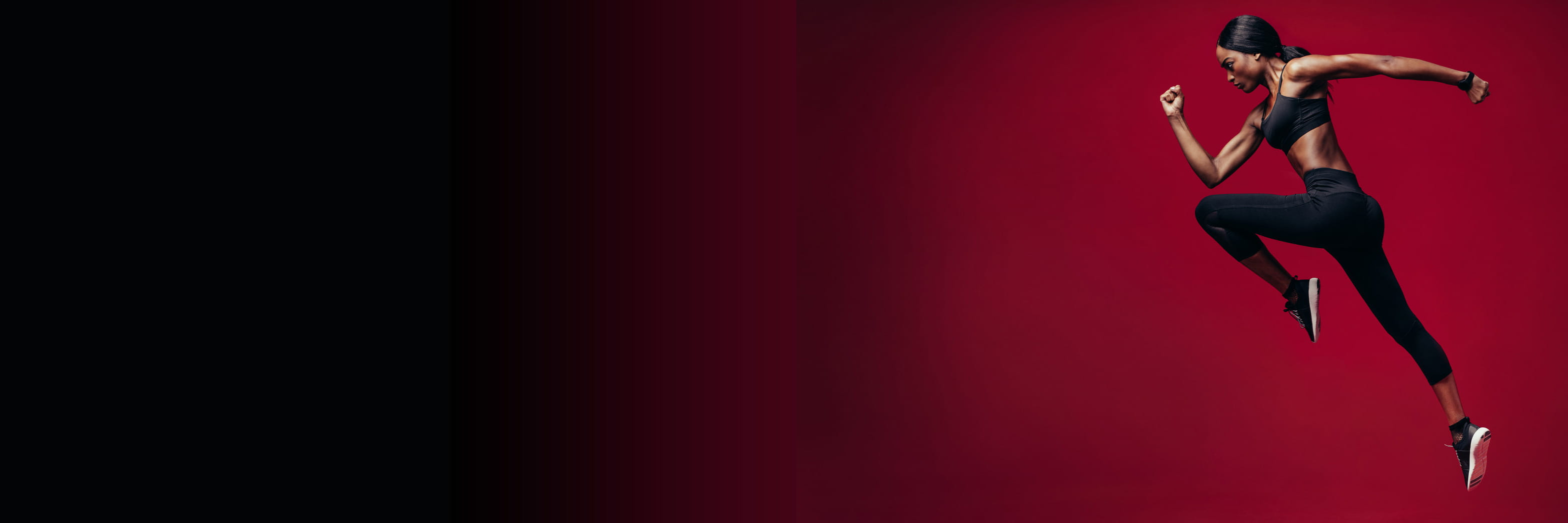 Sports woman running over red background. Full length shot of healthy young african woman sprinting.