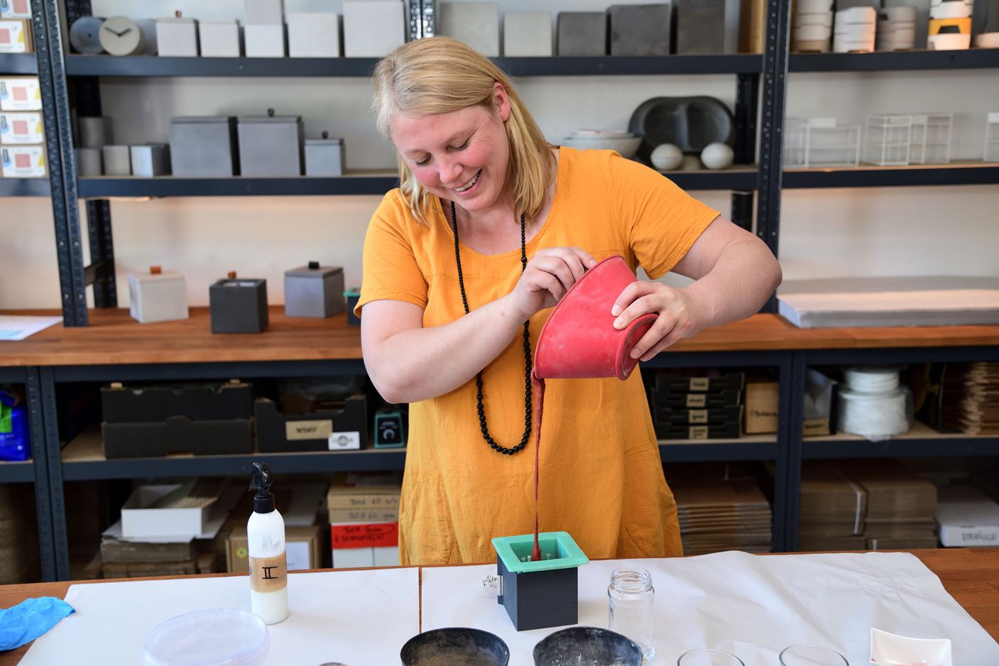 Diana Schmidt-Rothmeier, managing director of the Grellroth company, waters a bee house with cement coloured red.