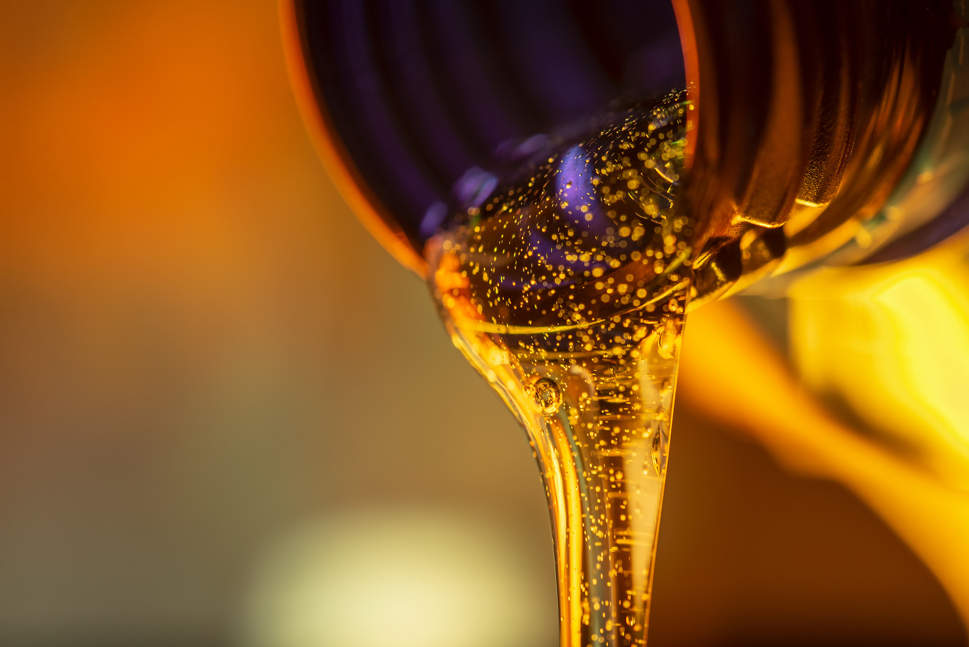 Liquid engine oil flows out of the neck of the bottle