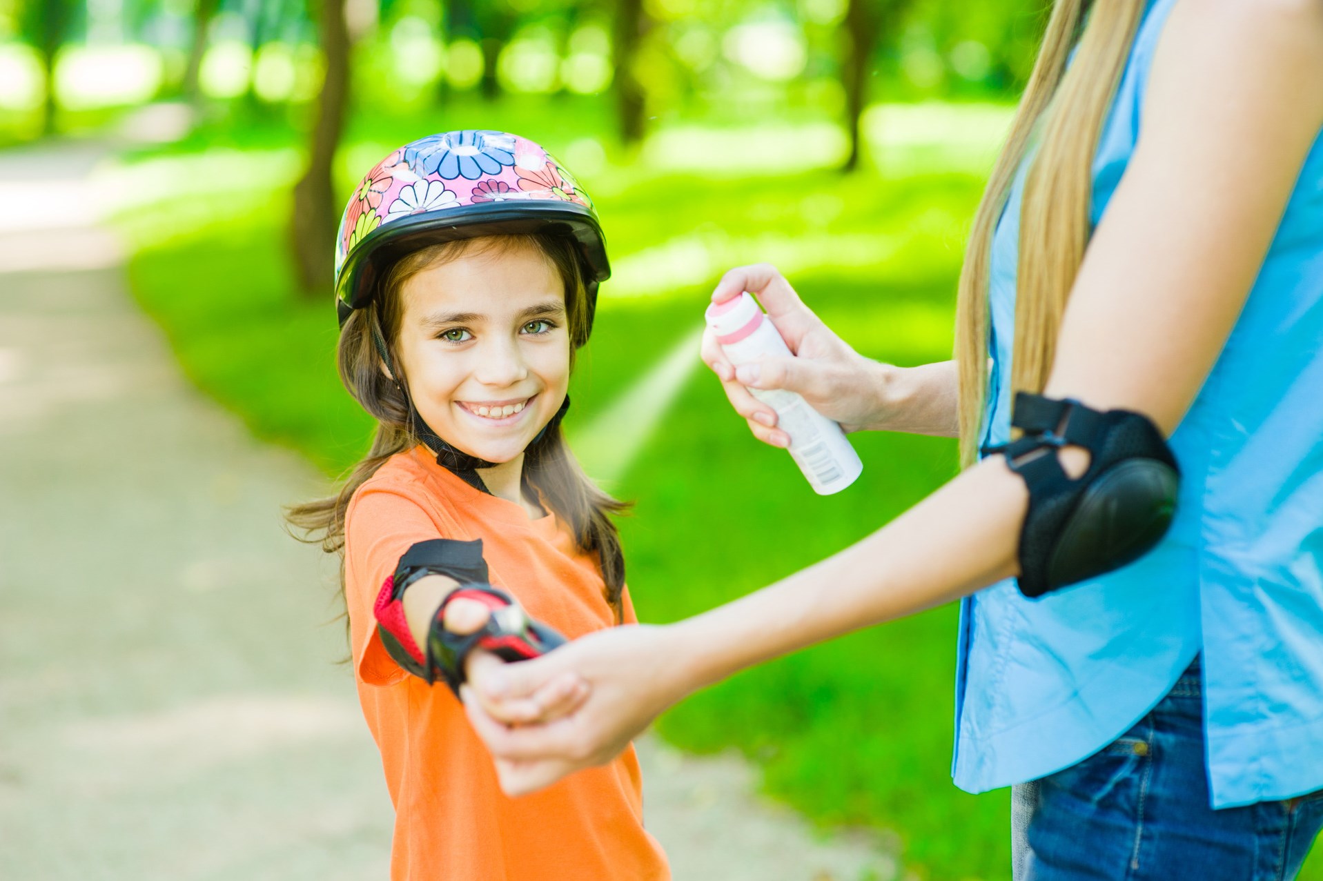 Mother spraying insect repellent on her child&amp;#39;s skin 