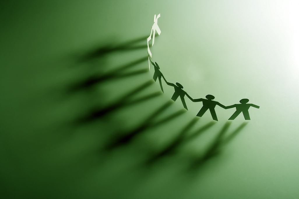 Gruppe von männlichen Papierketten, die Teamarbeit repräsentieren.