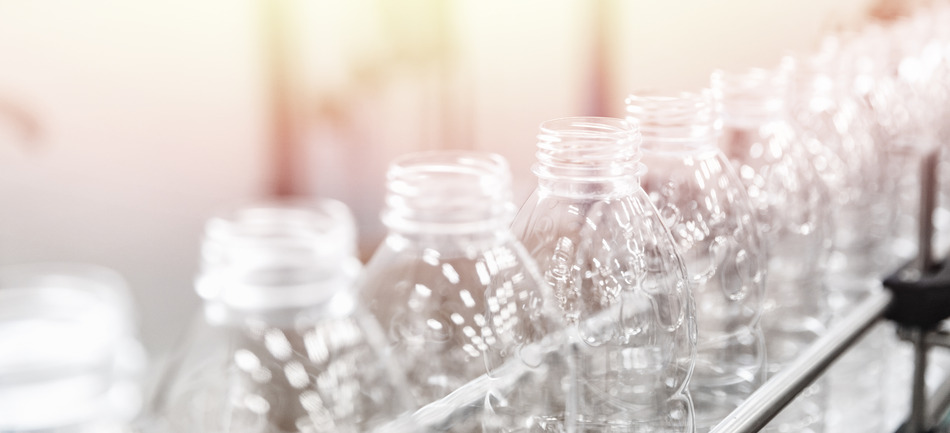 Production of PET plastic bottles on conveyor belt water and milk dairy factory. Vizualization of the beverage filling process.