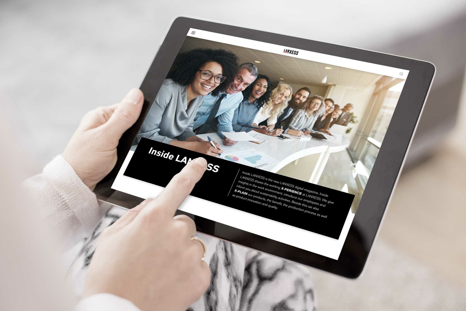 Woman reading the digital magazine Inside LANXESS on an iPad