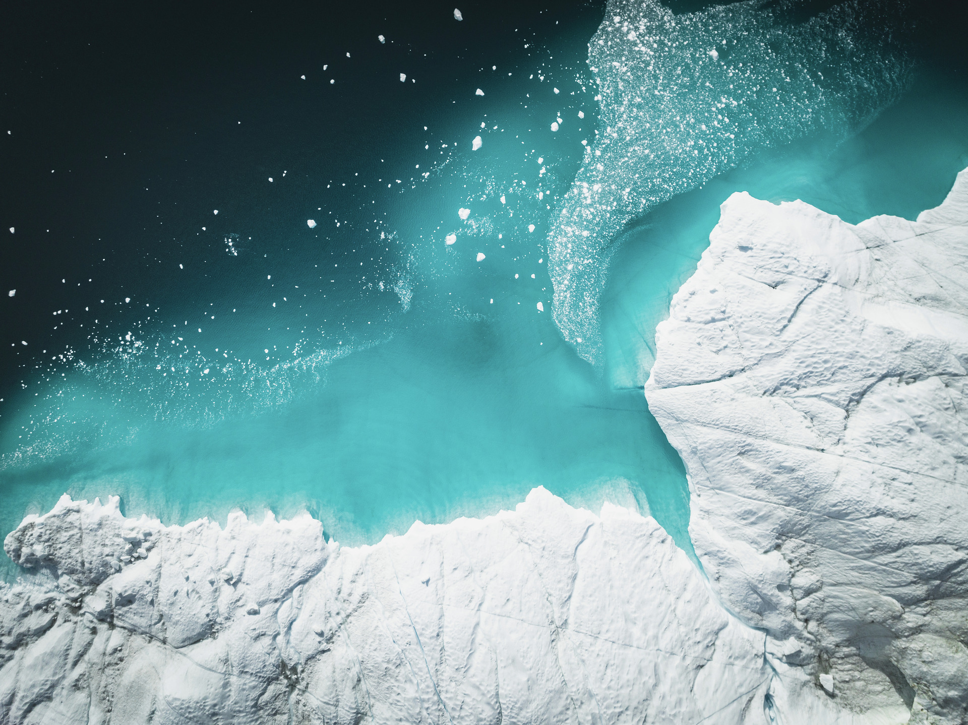 Bird's eye view of icebergs floating above the sea.