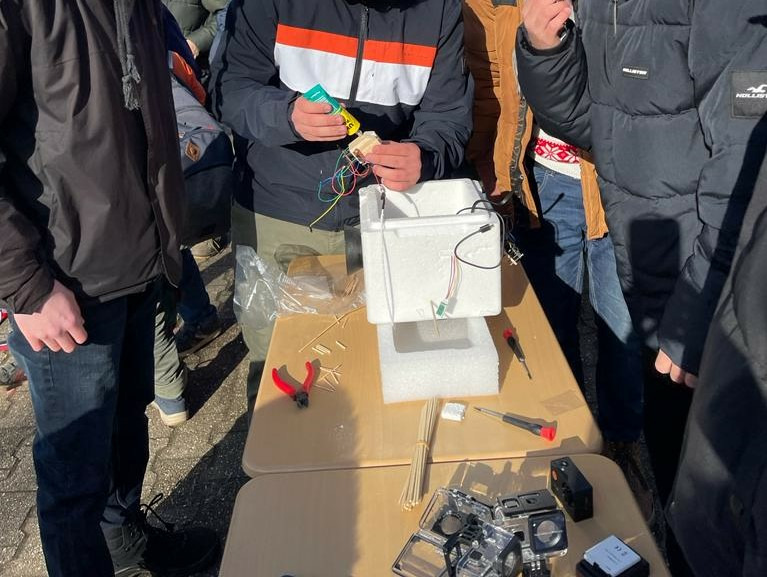 The students are preparing the balloon's technology for take-off.