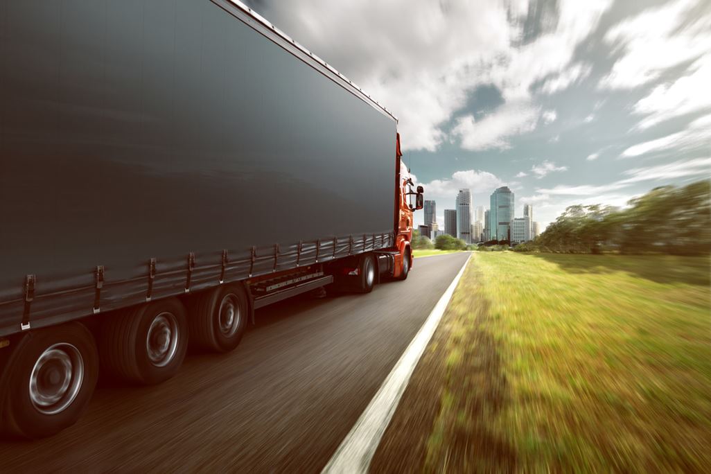 Truck on country road in the direction of the city