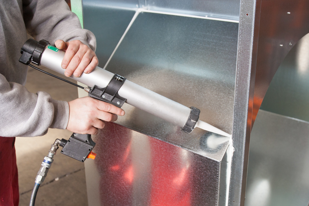 worker apply silicone sealant with gun