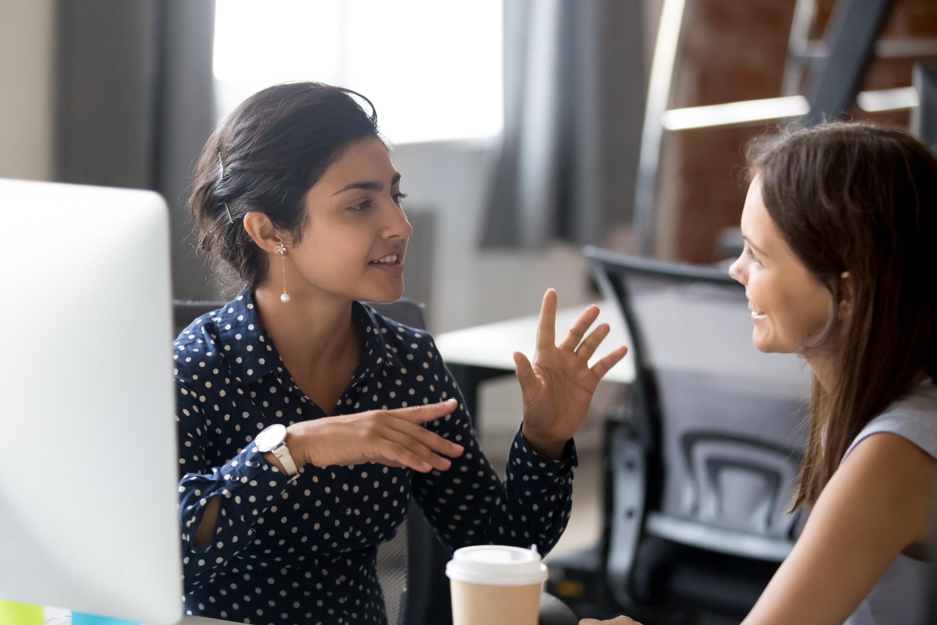 Friendly female colleagues are having pleasant conversation