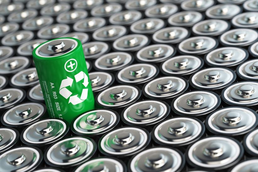 Battery recycling concept. Green energy, Background from battaries and one with green recycling sign.