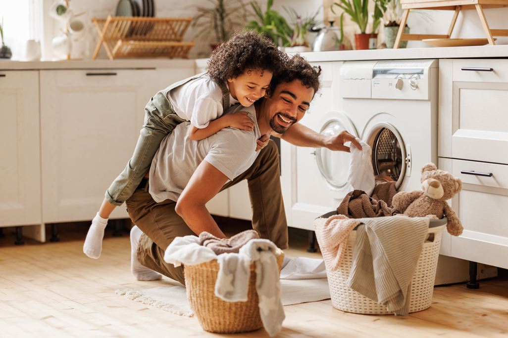 Vater und Sohn waschen gemeinsam Wäsche