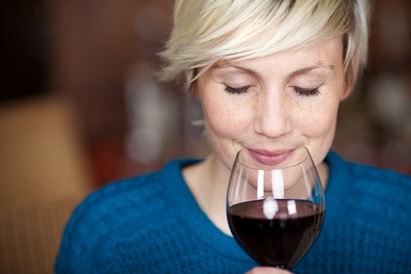 smiling woman enjoying red wine