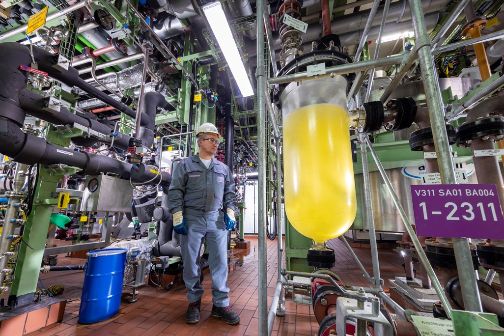 Man checks vat with yellow liquid