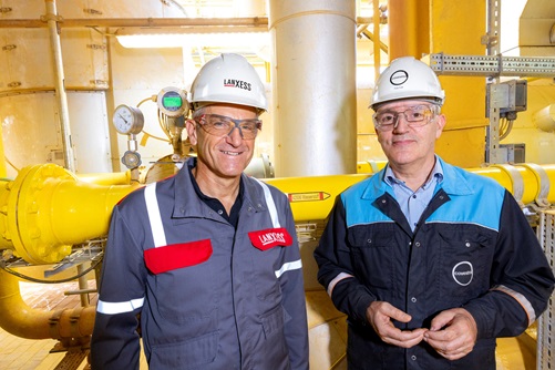 Michael Ertl, Leiter des Geschäftsbereichs Inorganic Pigments bei LANXESS, und Rob Eek, Produktionsleiter bei Covestro in Krefeld-Uerdingen, stehen vor der neuen Wasserstoffleitung, die die Produktionsanlage für Eisenoxide von LANXESS versorgt.